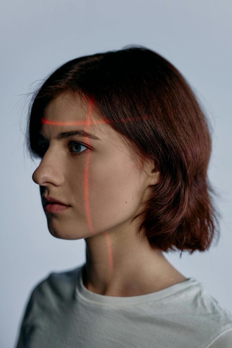 Side profile of a woman with laser lines on face, illustrating modern technology.